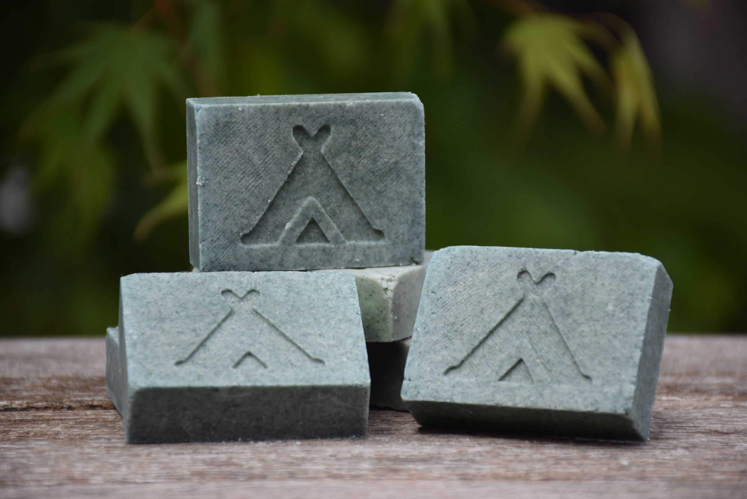 Groene shampoo en shower bar met logo van The Boomgaard een tentje erop